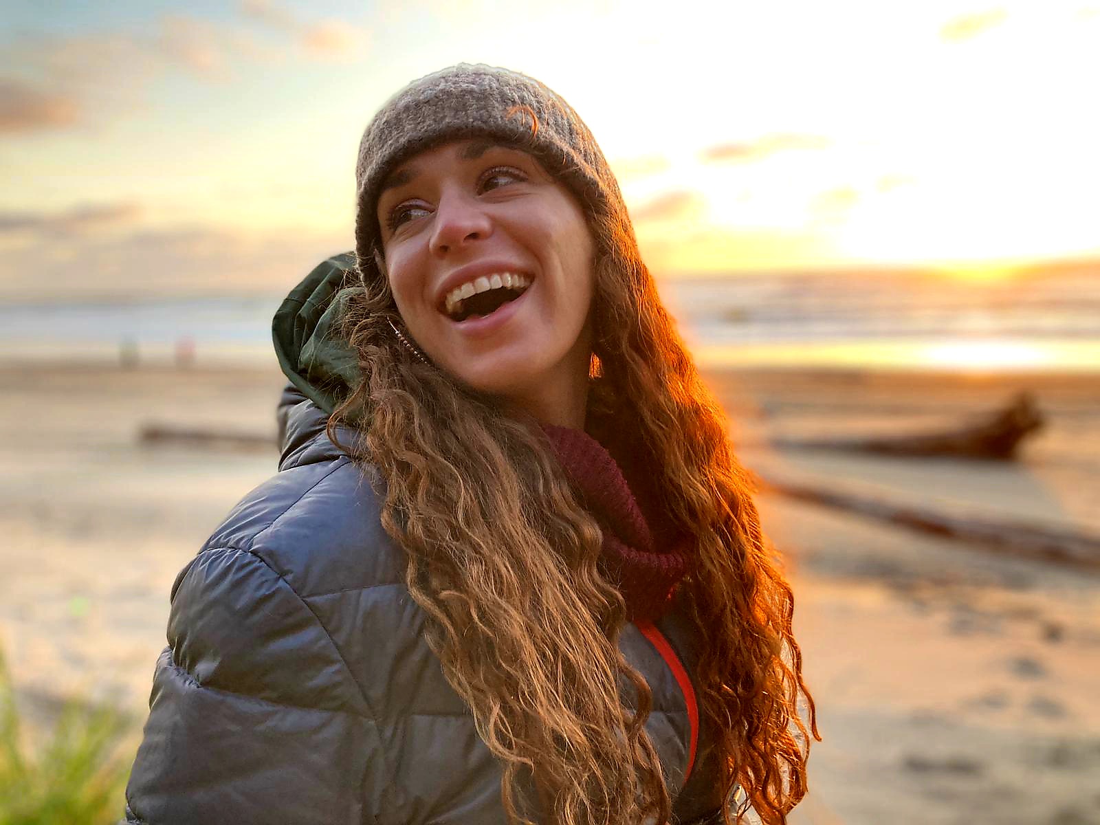 Zafiro Larsen, standing on a beach at sunset and grinning widely