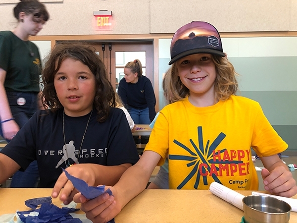Two Camp Fire campers, one smiling brightly and wearing a bright yellow Spark t-shirt
