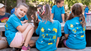 A group of young campers wearing Skills and Thrills Camp Fire t-shirts