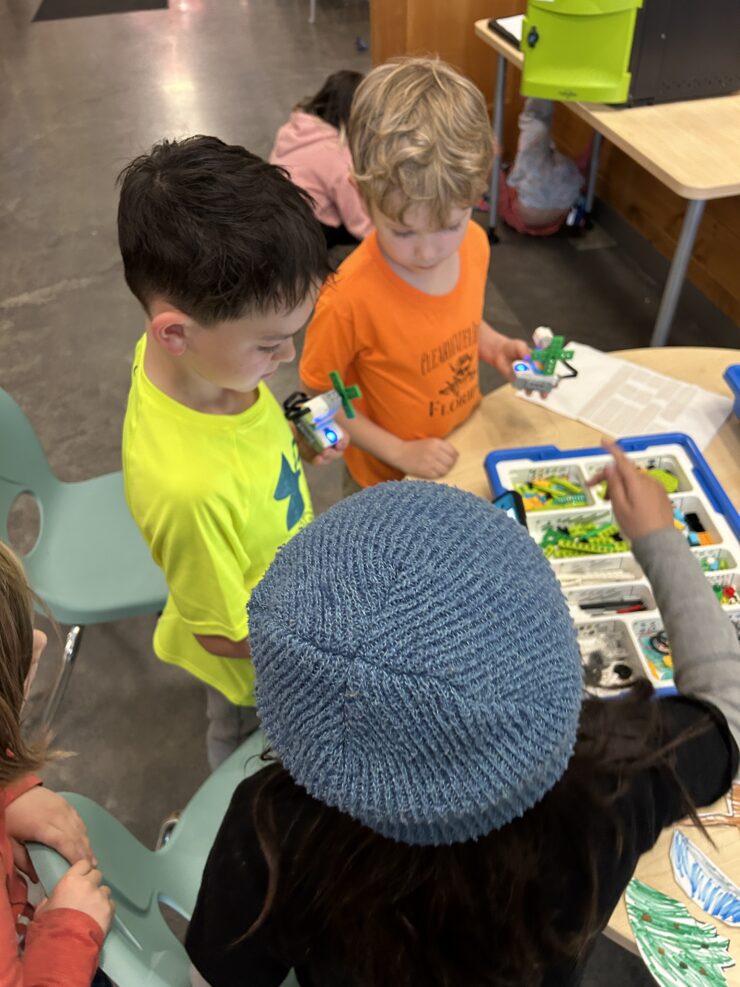 Several youth use LEGO robotics pieces to build robotic fans