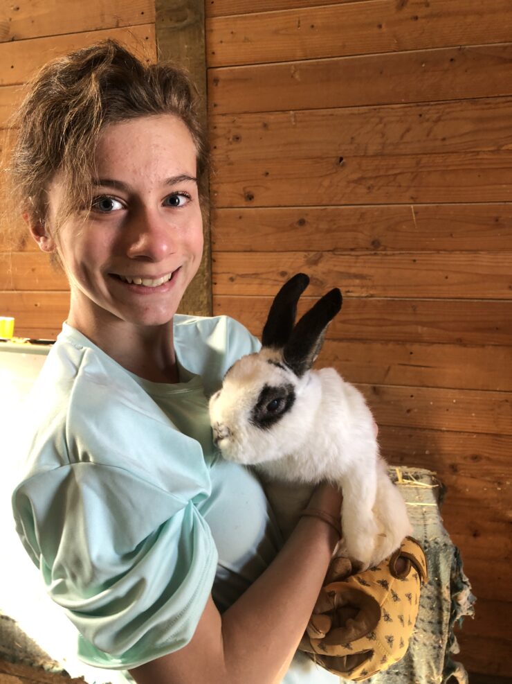 Teen Connects participant loves on bunny at animal rescue farm