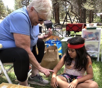 Cheryl McCoy camp nurse puts a band-aid on a camper.