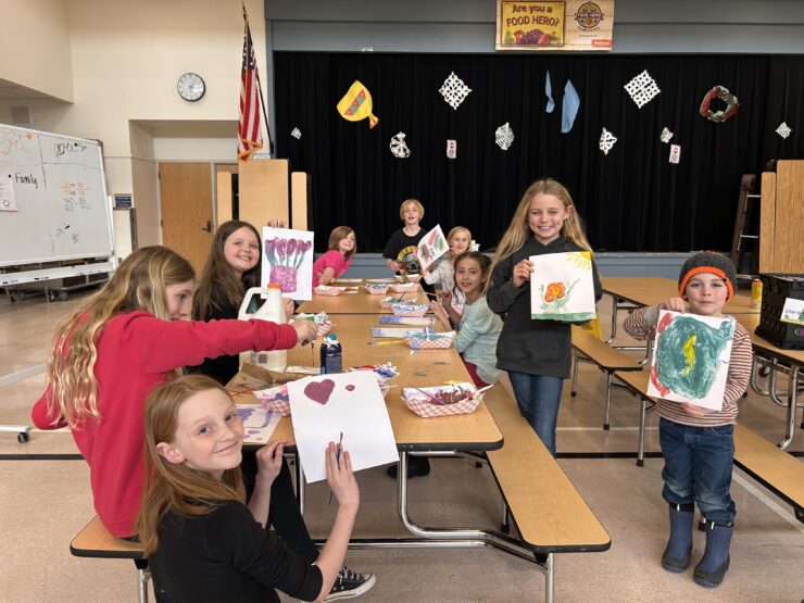 Kids show their paintings in afterschool program.