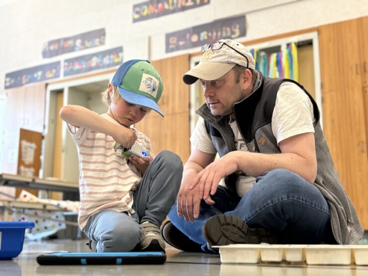 Parent engaging with child in a robotics exercise.