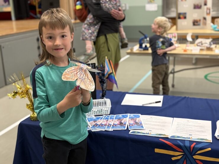Youth holds a homemade butterfly.