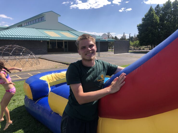 Staff member standing in front of waterslide.