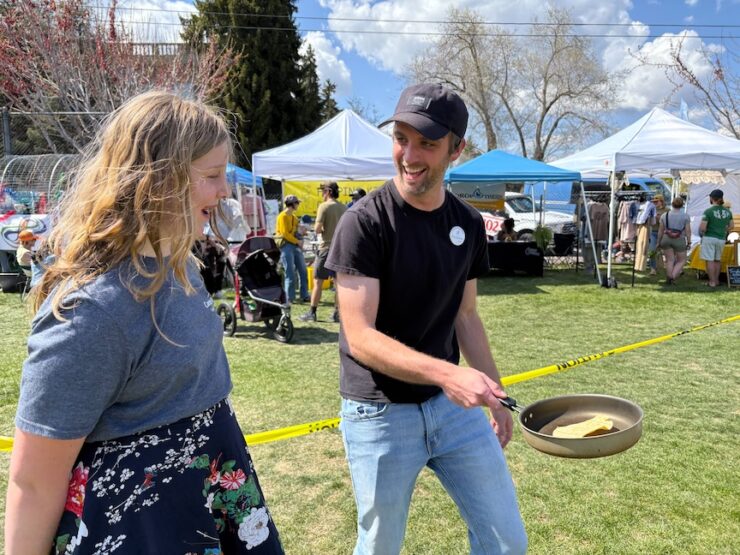 Andrew Blaylock flips a tortilla with a teen volunteer.