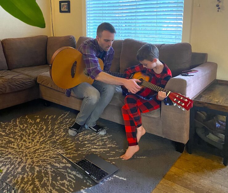 Andrew Blaylock gives a youth a guitar lesson.