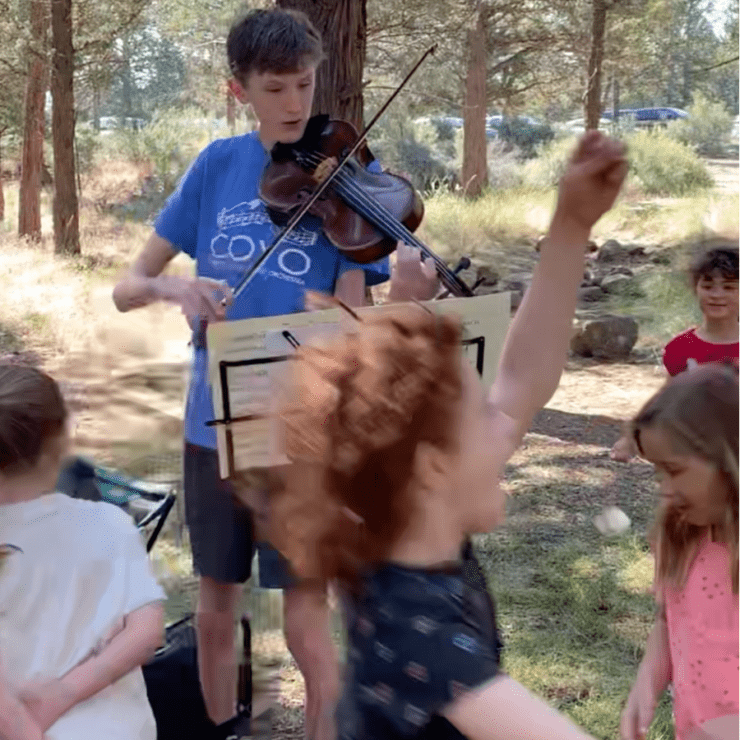 Clark plays the violin for campers.