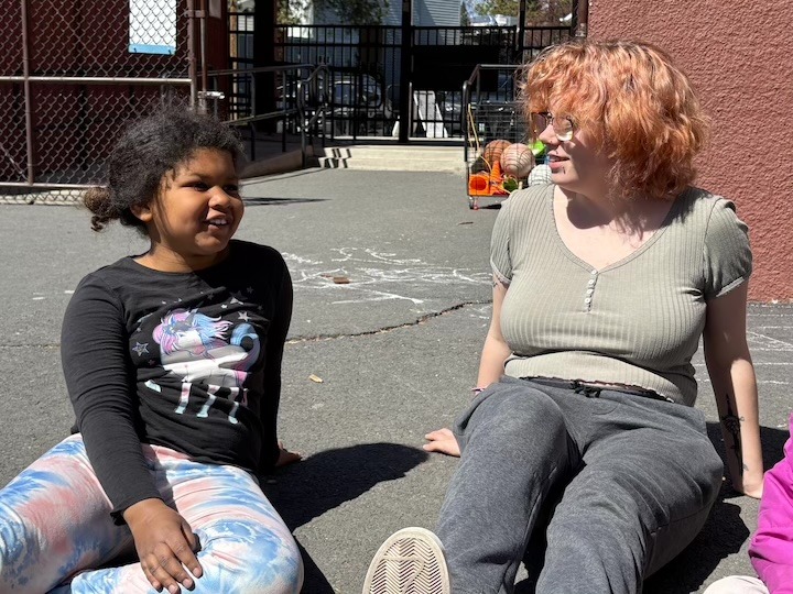 No School Day Camp camper talks with a Camp Fire staff member.