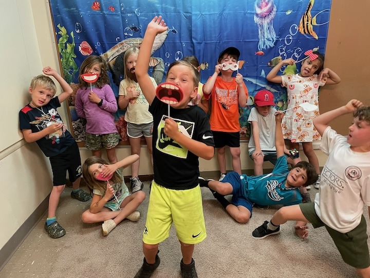 Group of Camp Fire Afterschool youth playing with masks and other fun face decorations.