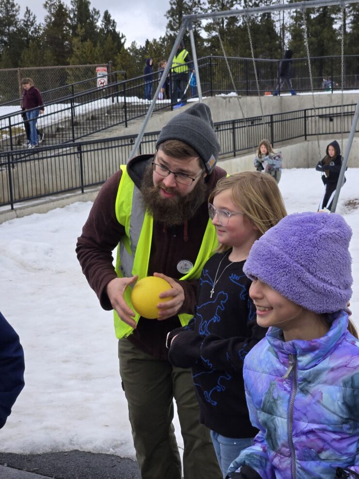 Camp Fire Afterschool staff member engages youth in collaborative playground games.