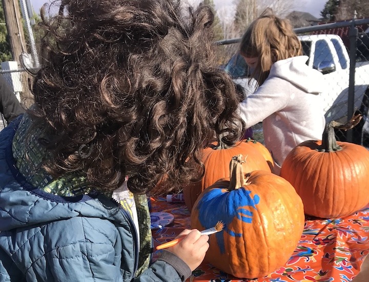 Youth painting pumpkins.