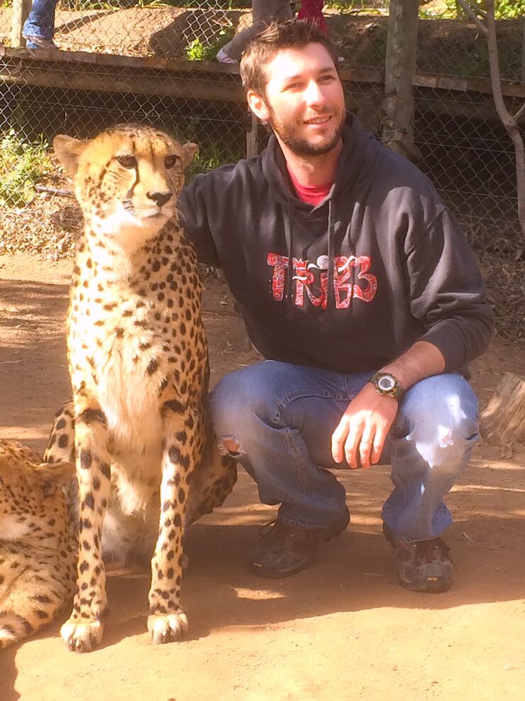 Jesse Flury poses with a cheetah.
