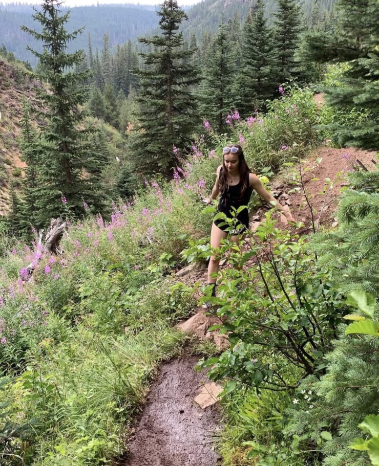 Kamryn Sherman walks on a mountain trail.