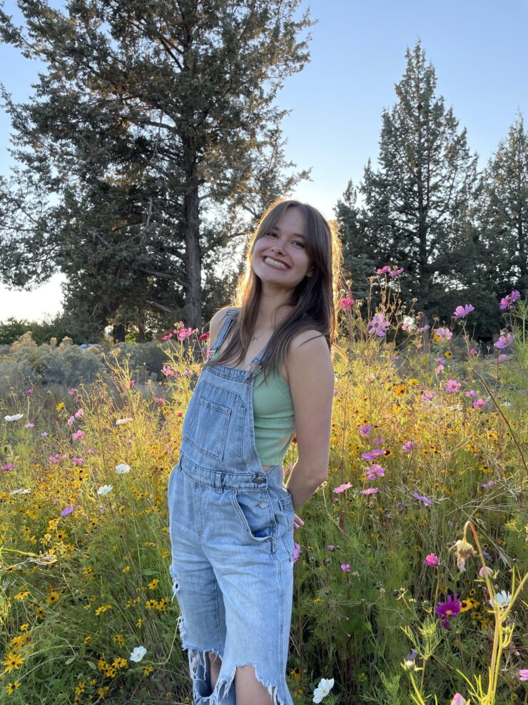 Kamryn Sherman standing in a field of flowers.