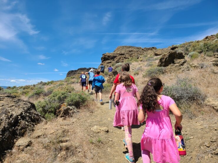 Kids hiking across a rocky plain.