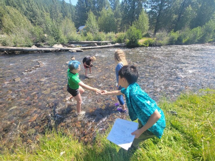 Camp Fire kids work together on a stream study